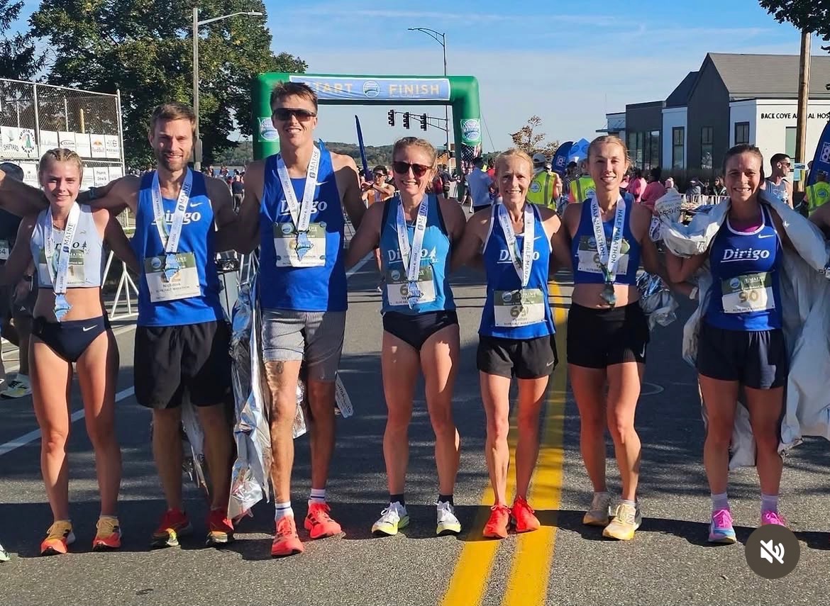 Seven Dirigo runners wearing medals near the Maine Marathon finish arch.
