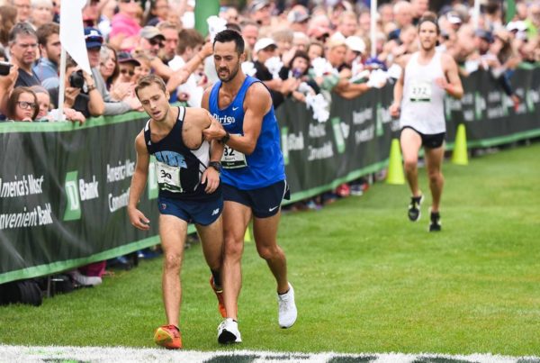 Rob Gomez helping Jesse Orach near the Beach to Beacon finish in 2017.